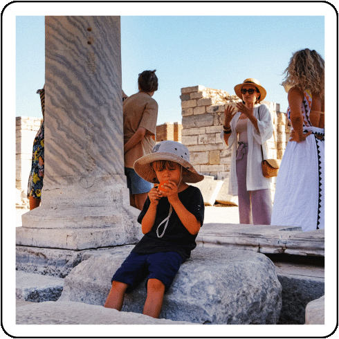 Image description: A child eating an orange at an ancient ruin.